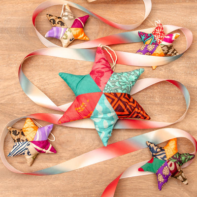 Colorful star-shaped fabric ornaments with ribbons on a wooden surface