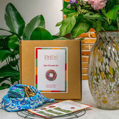 Sari wreath kit with materials and instructions on a table with plants in the background