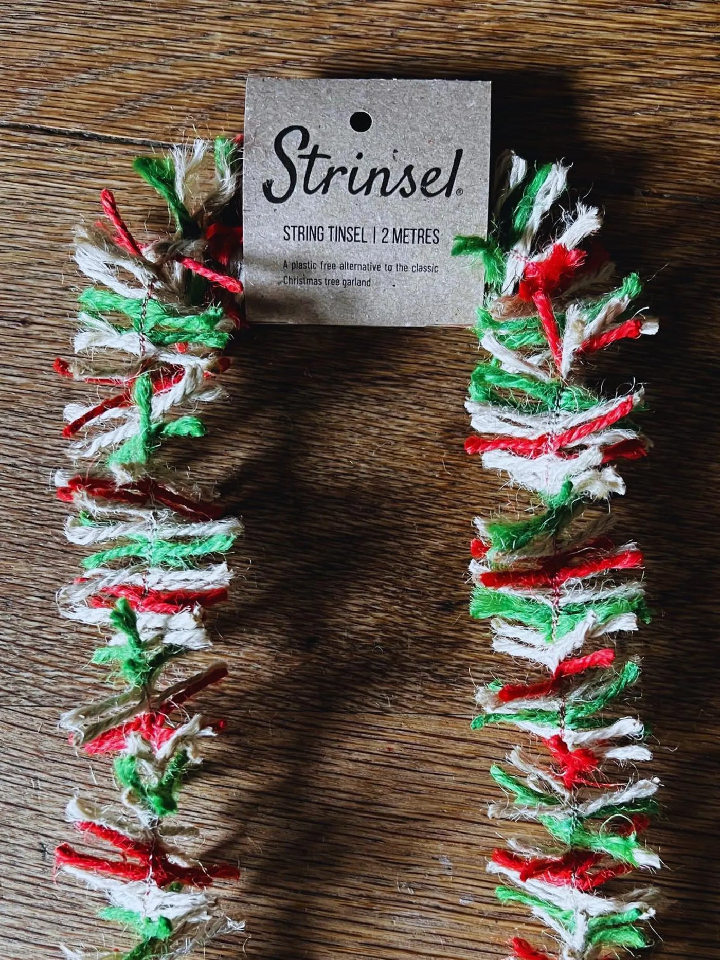 Decorative string tinsel with a 'Strinsiel' tag on a wooden surface