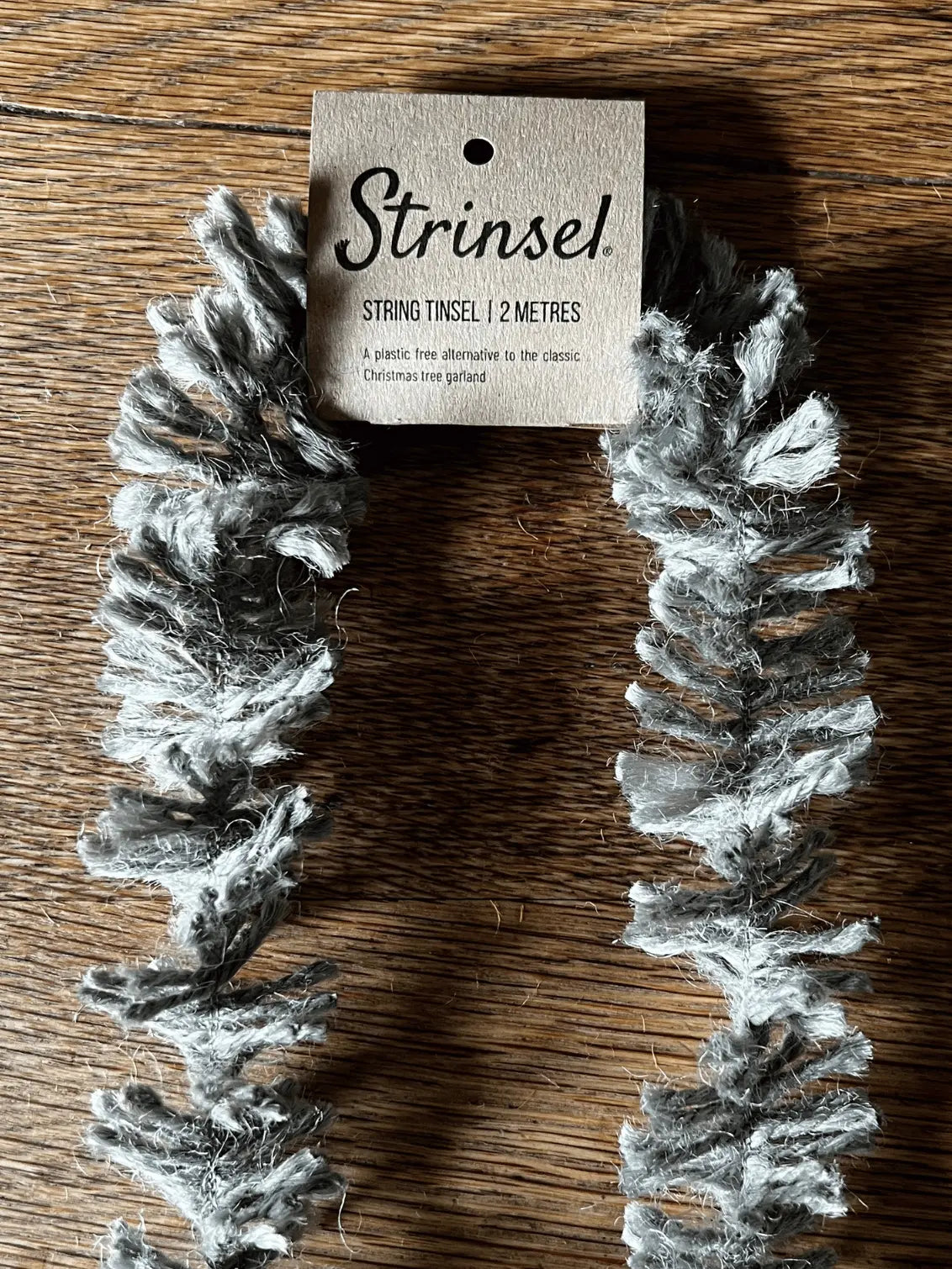 String tinsel with a 'Strinsel' tag on a wooden surface