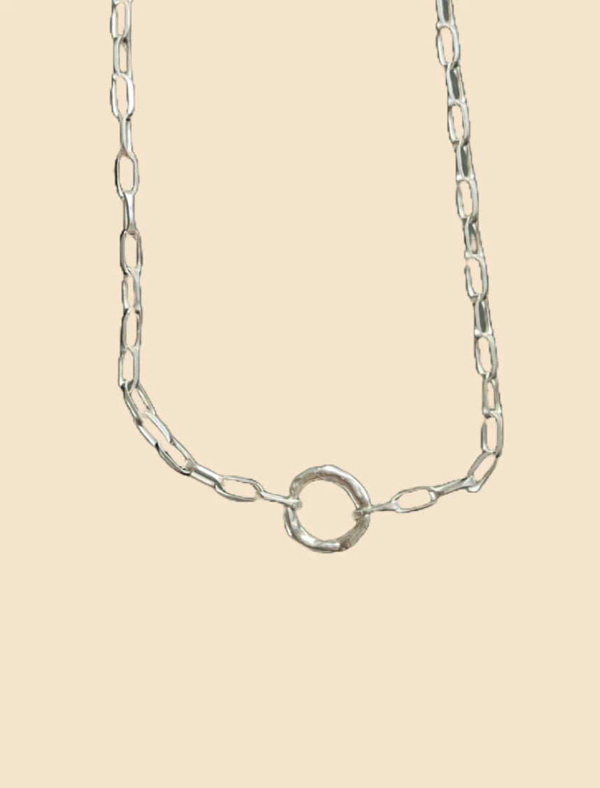 Silver chain necklace on a beige background