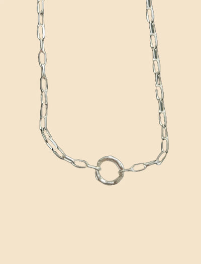 Silver chain necklace on a beige background