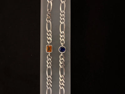 Silver chain bracelet with gemstone accents on a black background