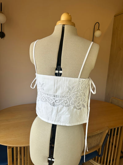 White lace top on a mannequin with a neutral background