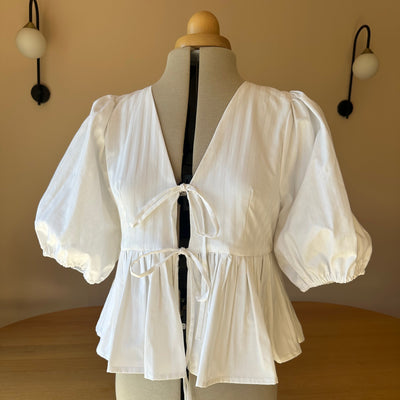 White dress on a mannequin against a neutral background