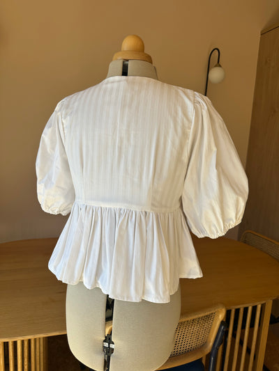 White dress on a mannequin against a neutral background