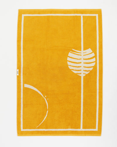 Yellow towel with white leaf design on a white background