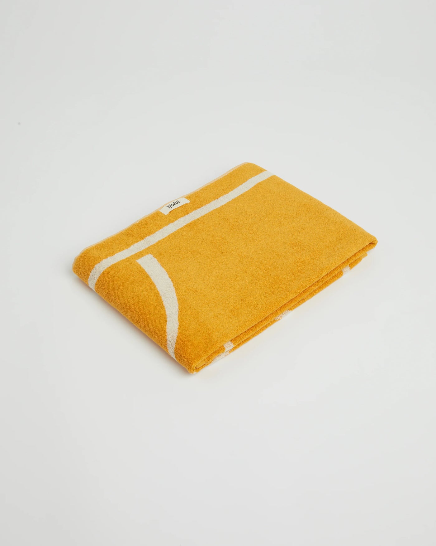 Yellow towel with white stripes on a light gray background