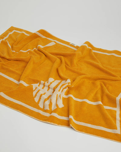 Yellow towel with white stripes and logo on a light gray background