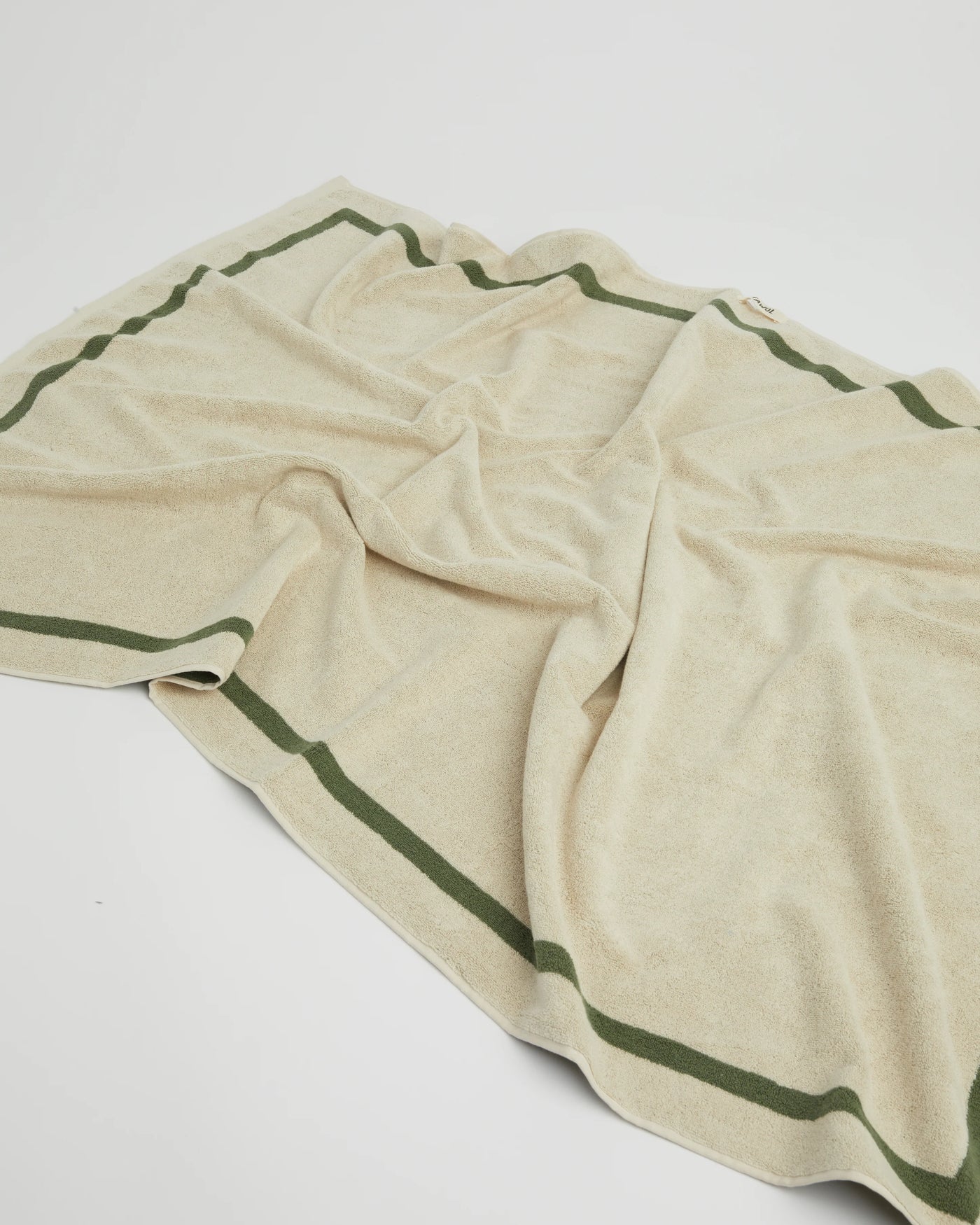 Beige towel with green stripes on a white background