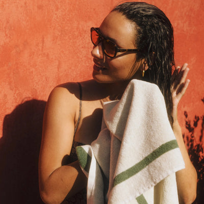 Woman holding a towel against a red wall