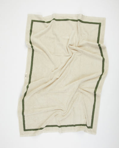 Beige blanket with green border on a white background