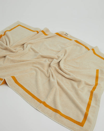 Beige towel with orange border on a white background