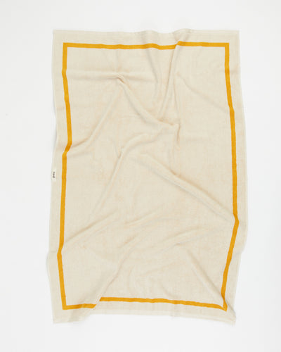 Beige towel with yellow border on a white background