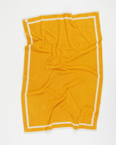 Yellow towel with white trim on a white background