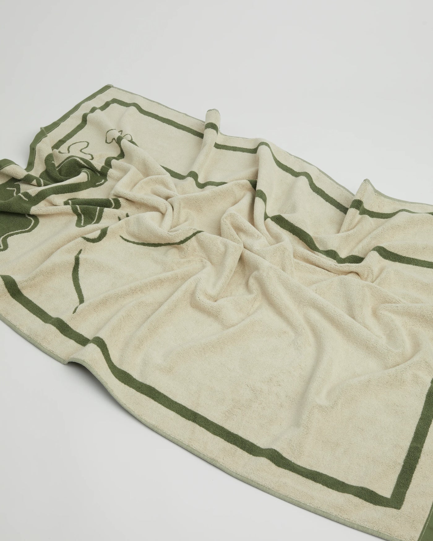 Beige towel with green border on a white background