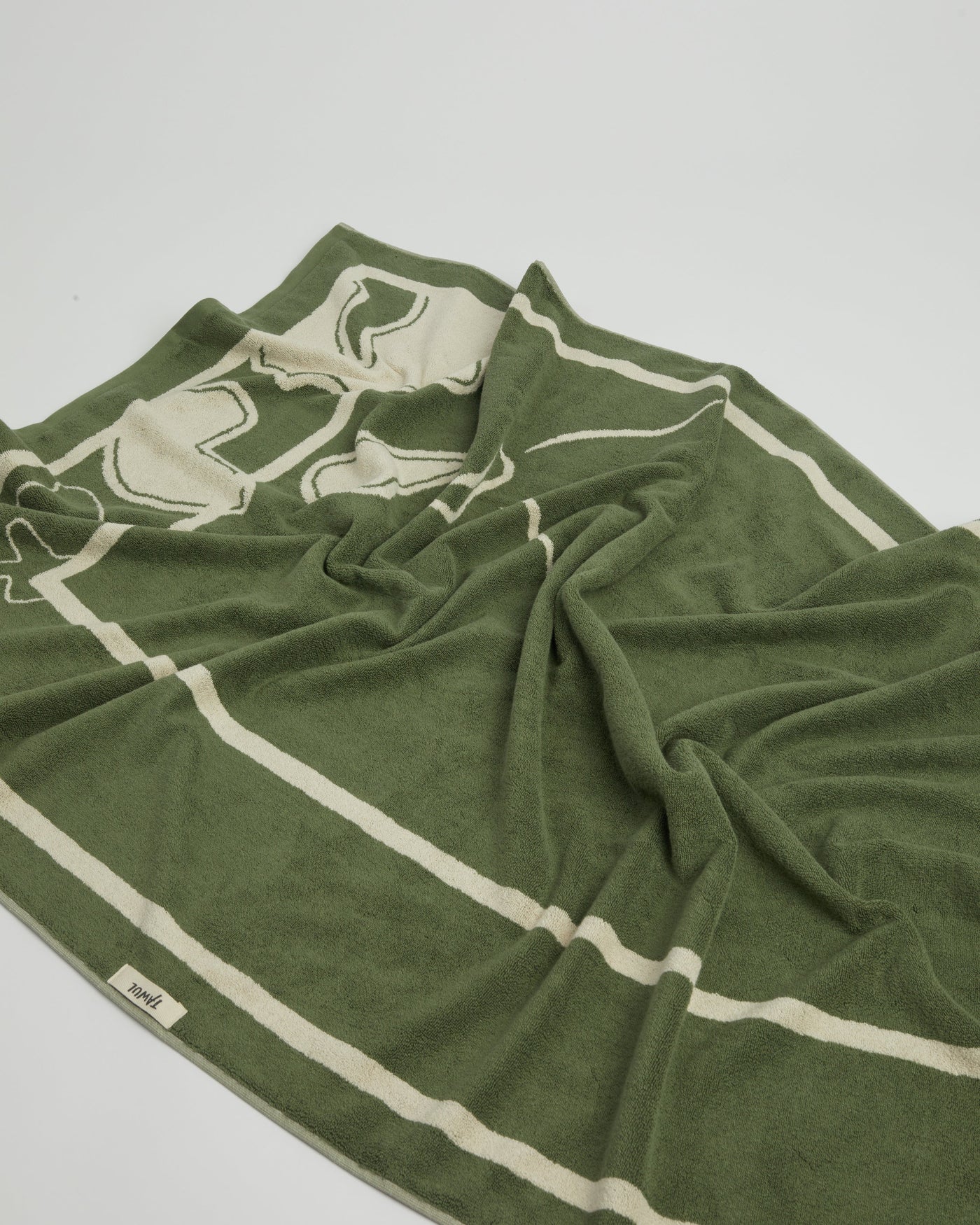 Green towel with white stripes on a light gray background