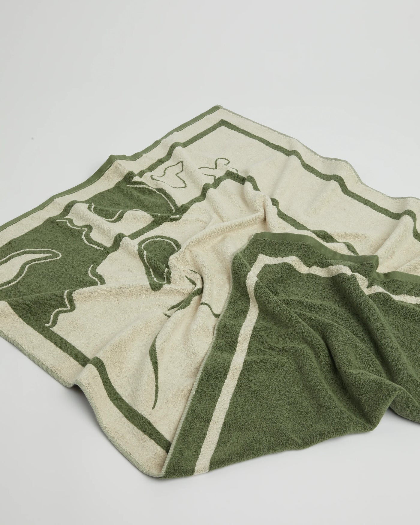 Green and beige towel with abstract design on a light gray background