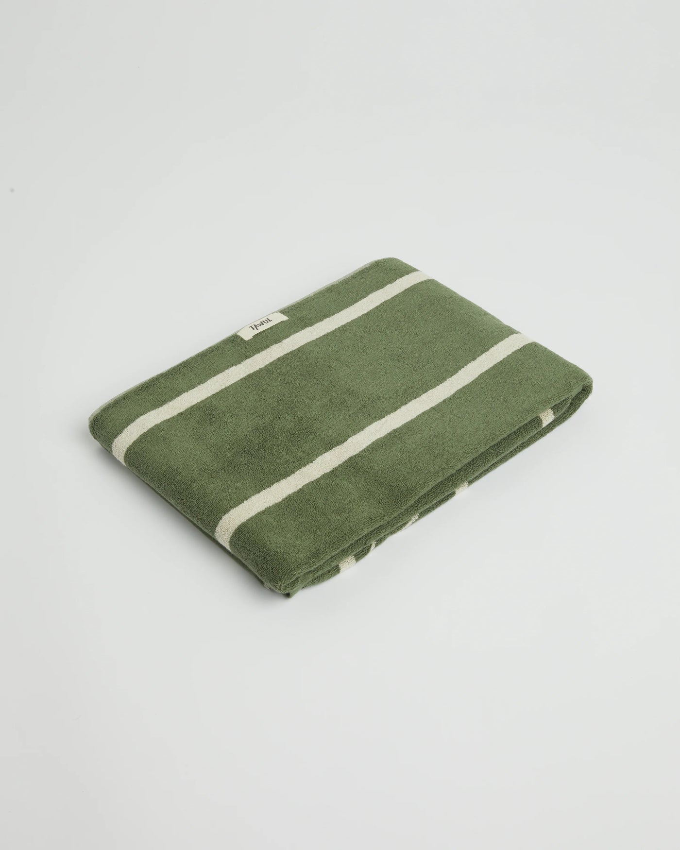 Green towel with white stripes on a light gray background
