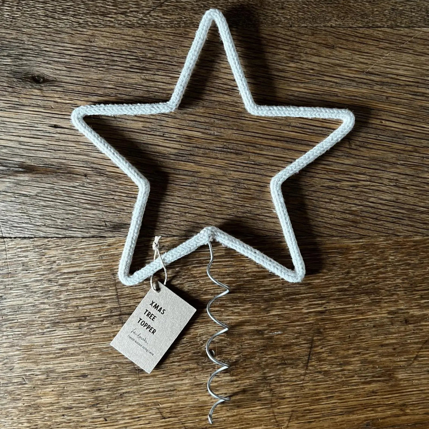 Star-shaped bottle opener with a tag on a wooden surface
