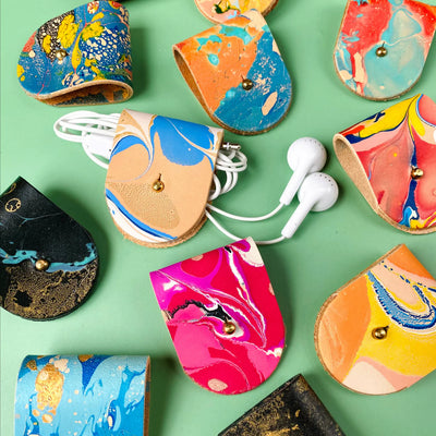 Colorful marble-patterned cases for electronic devices on a green background