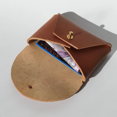 Brown leather case with a gold button on a light gray background
