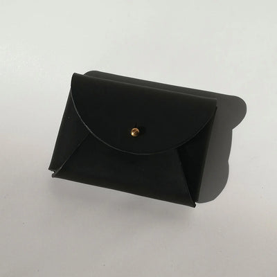 Black leather pouch with a gold button on a white background