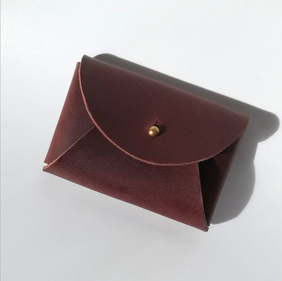 Brown leather pouch with a gold clasp on a white background