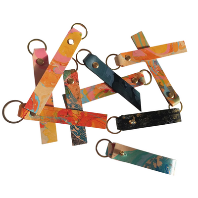 Colorful keychains with geometric designs on a white background