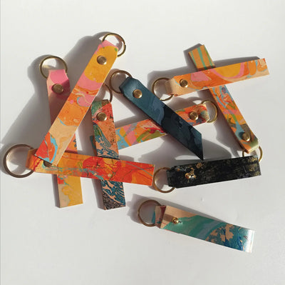 Colorful keychains with geometric designs on a white background