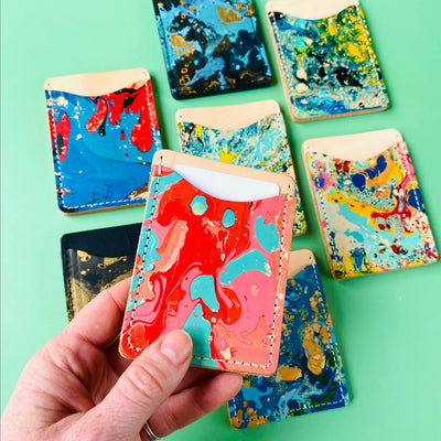 Colorful marbleized phone cases on a green background