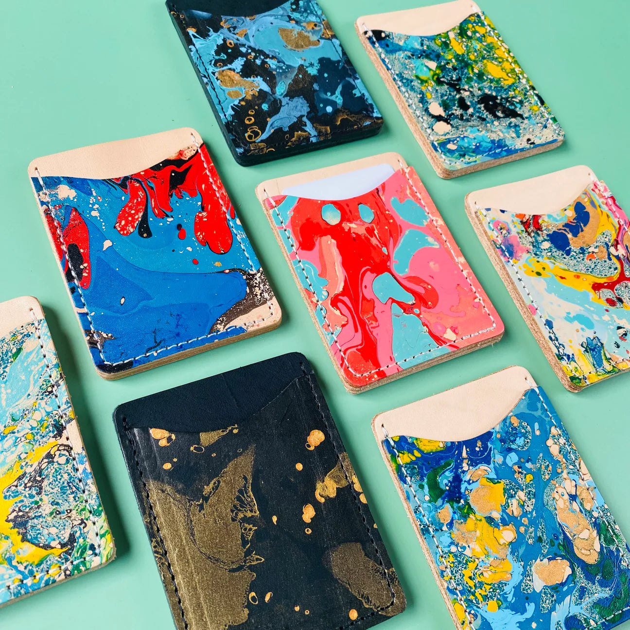 Colorful marbled phone cases on a teal background
