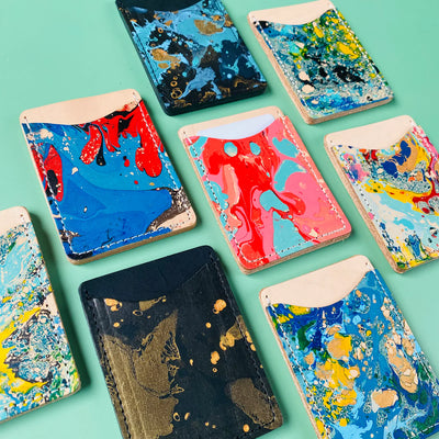Colorful marbled phone cases on a teal background