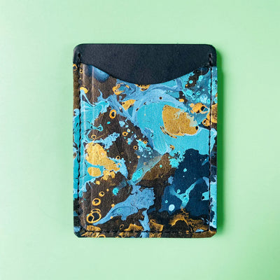Marbled design cardholder with blue, gold, and black colors on a light green background