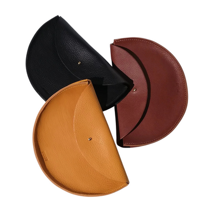 Three round leather bags in black, brown, and tan on a white background